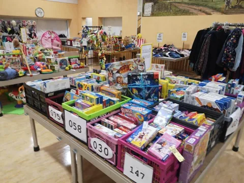 Verkaufstische mit Spielzeug, Fahrrädern und Kinderkleidung