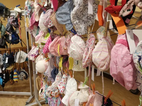 Kindermützen und Sonnenhüte am Ständer